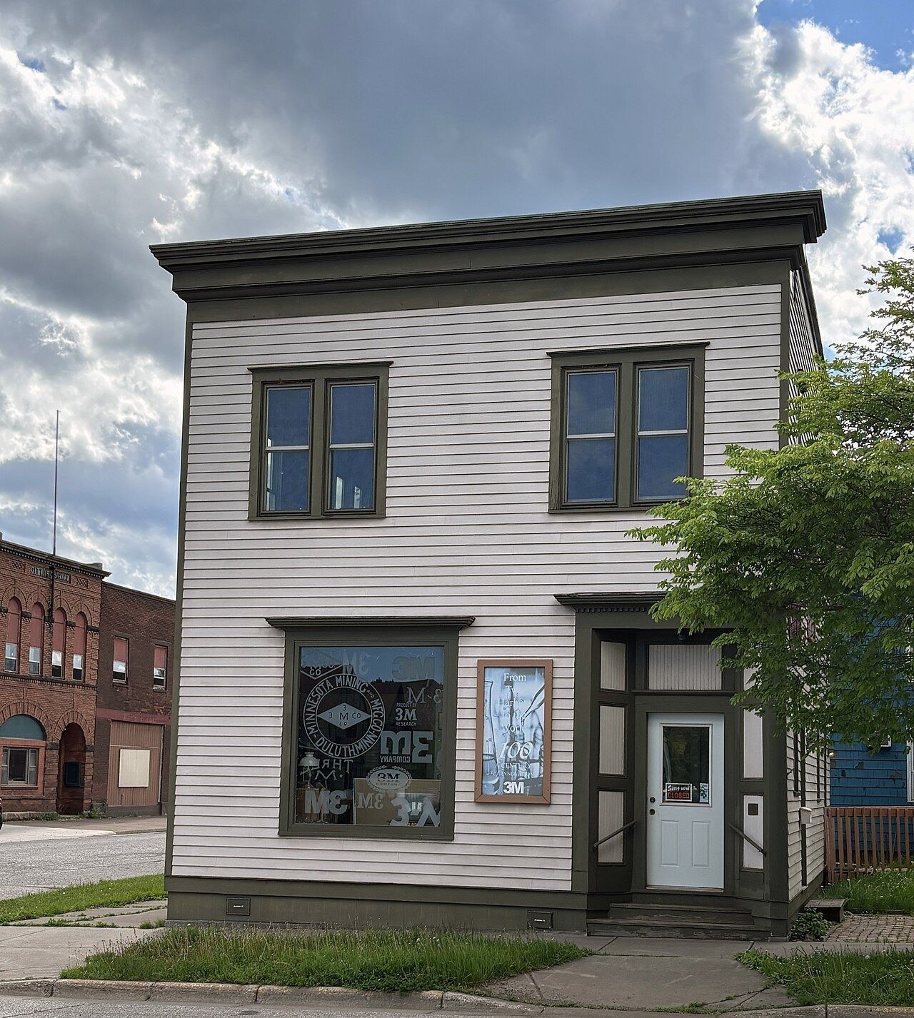 Small two-storey white wooden building