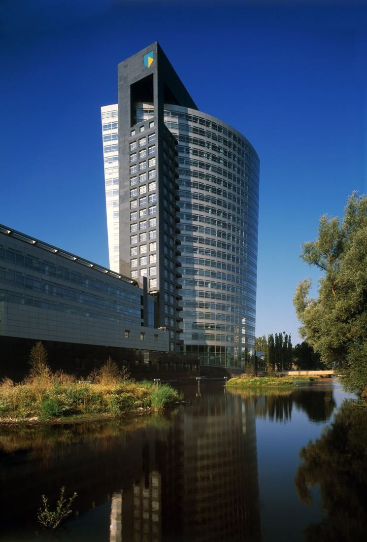 ABN AMRO: Curved glass tower reflected in a pond lined with reeds