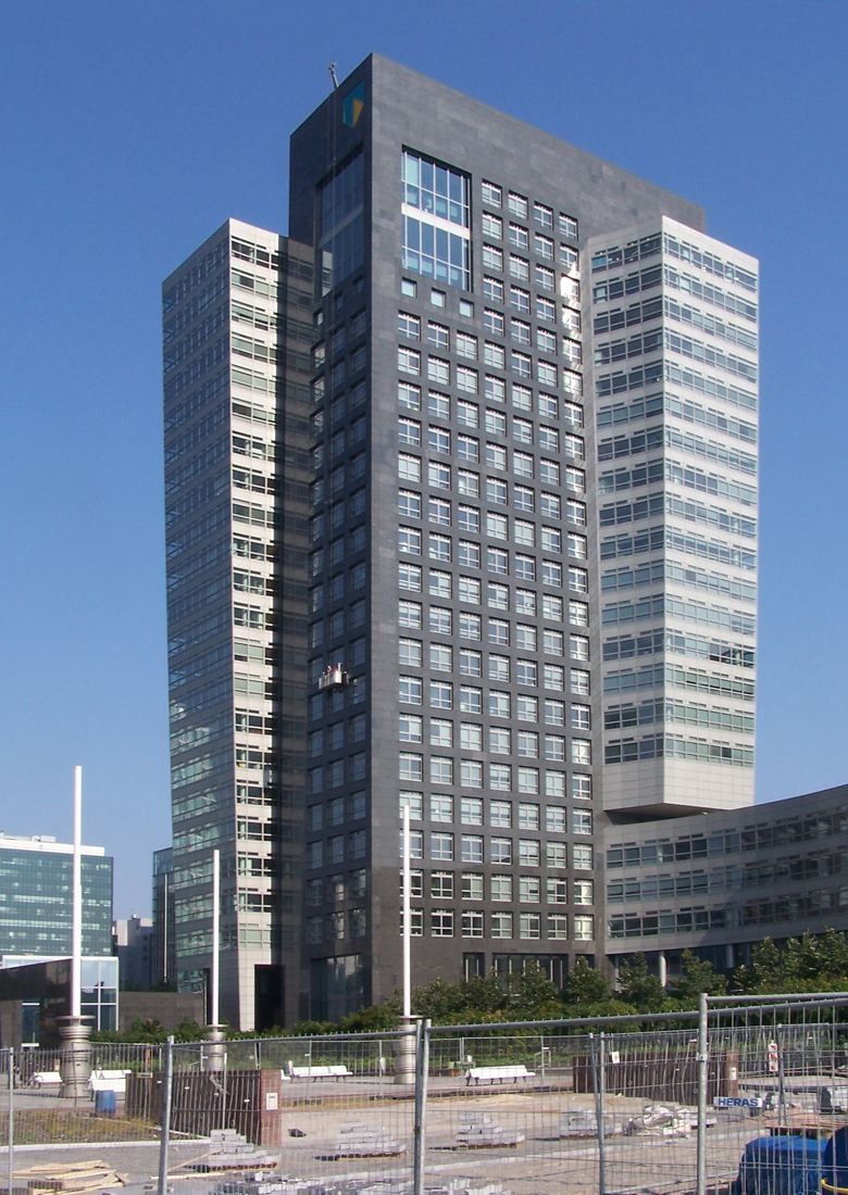 ABN AMRO: Dark tower with a glass corner volume beside a road