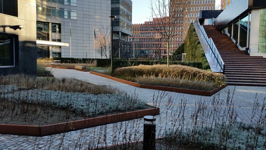 ABN AMRO: Landscaped court with planted beds, paved paths and a staircase between office buildings