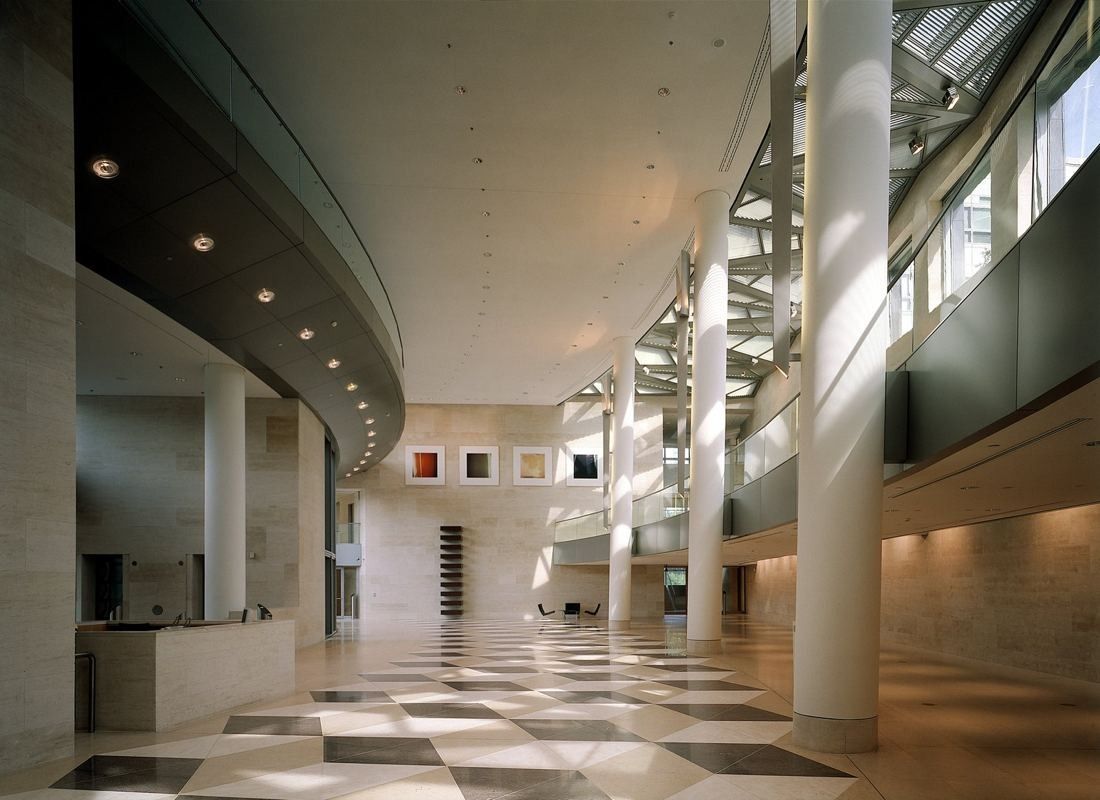 ABN AMRO: Long curved hall with tall white columns, a checkered stone floor and a gallery above