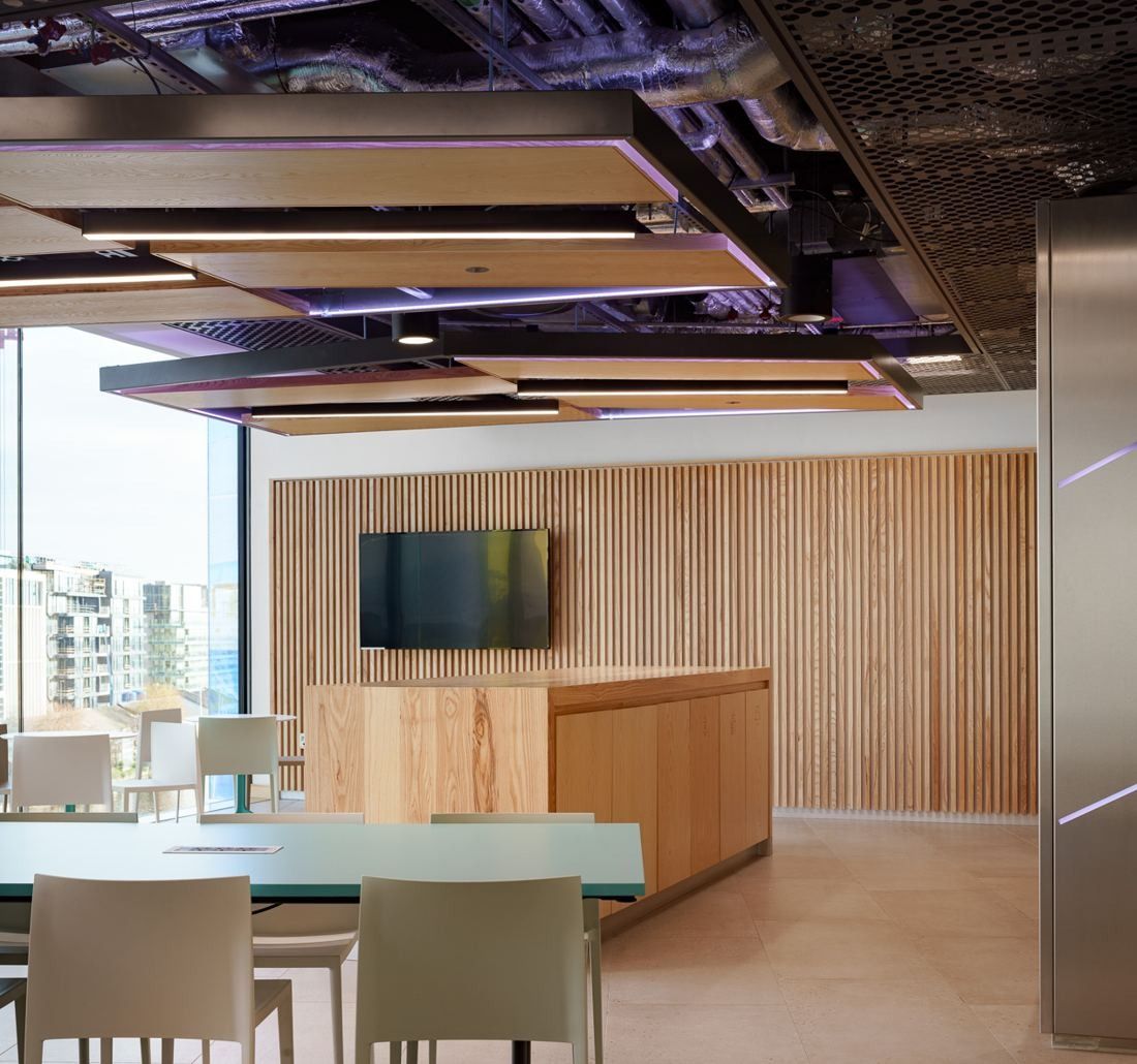 Accenture: Breakout area with a timber-slatted wall, screen and high tables