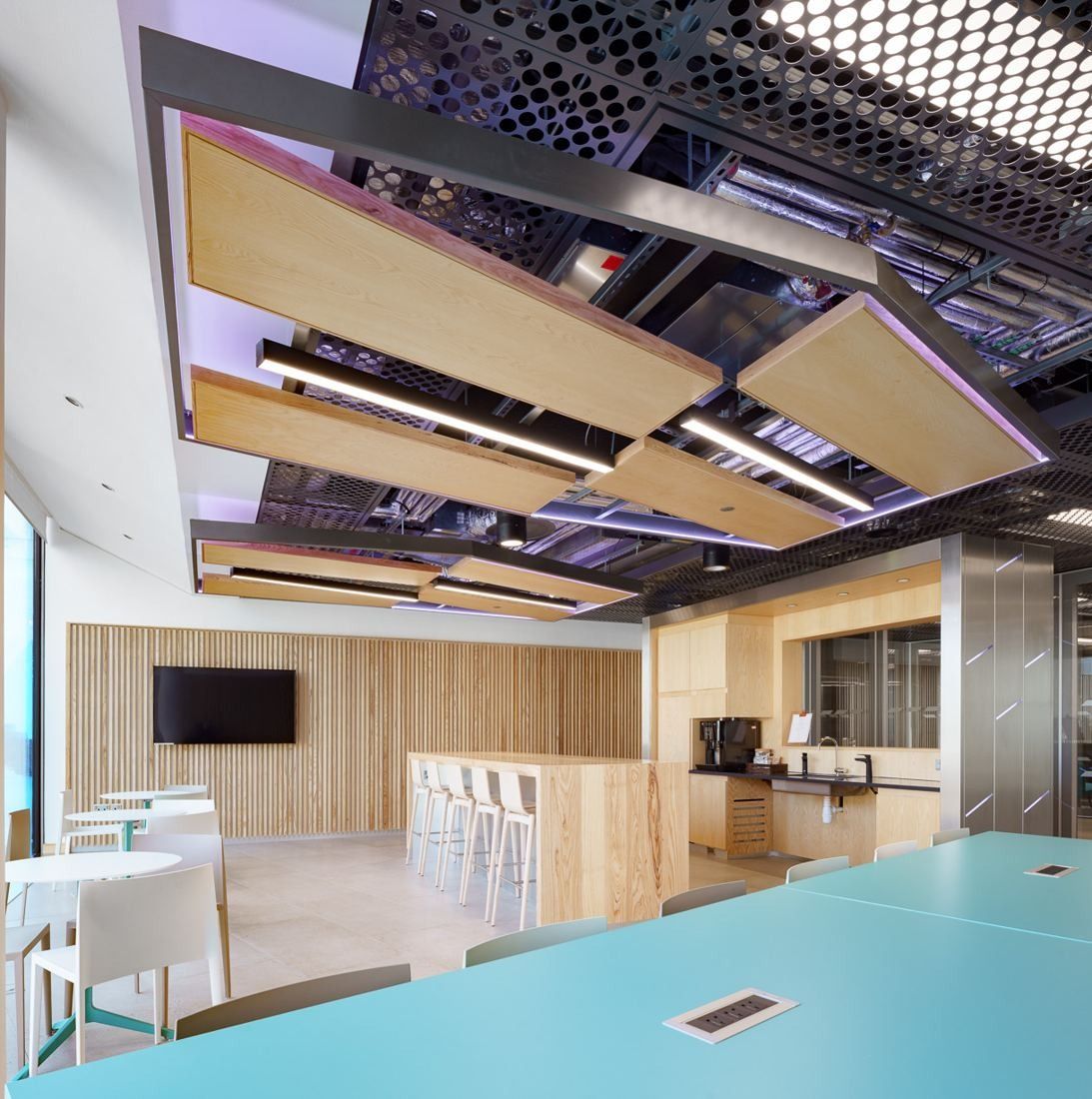 Accenture: Collaborative area with a long blue table, wooden ceiling rafts and a counter along the wall