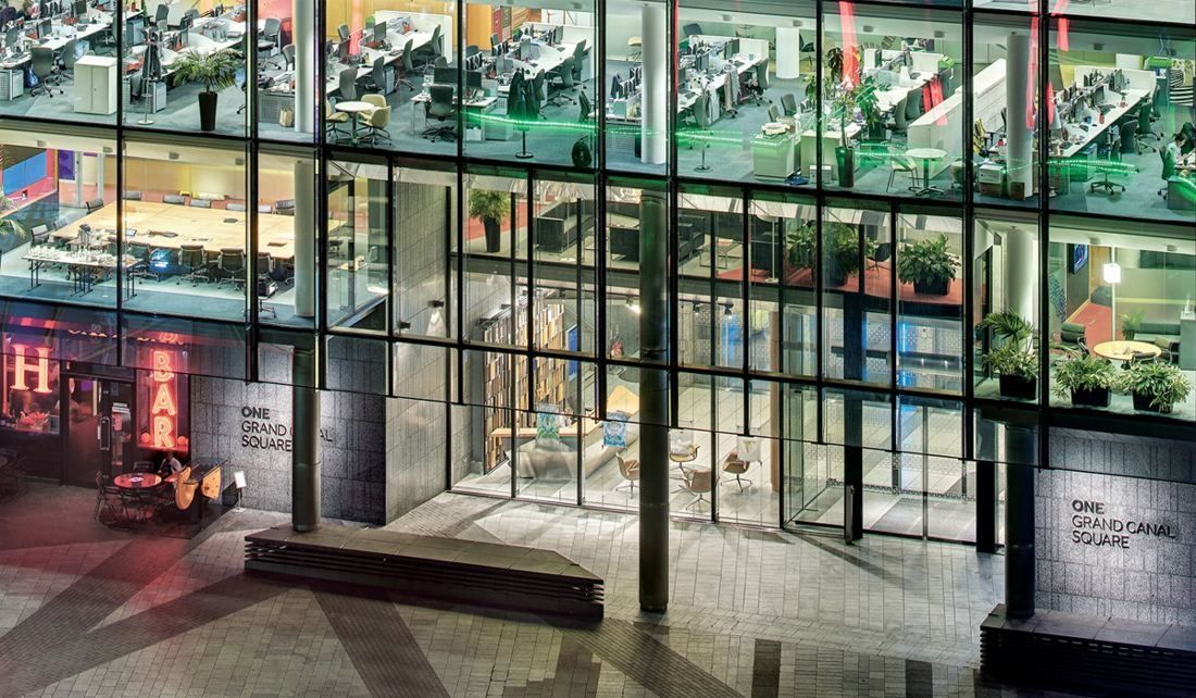 Accenture: Ground-floor entrance at night with a sign reading One Grand Canal Square and lit offices above