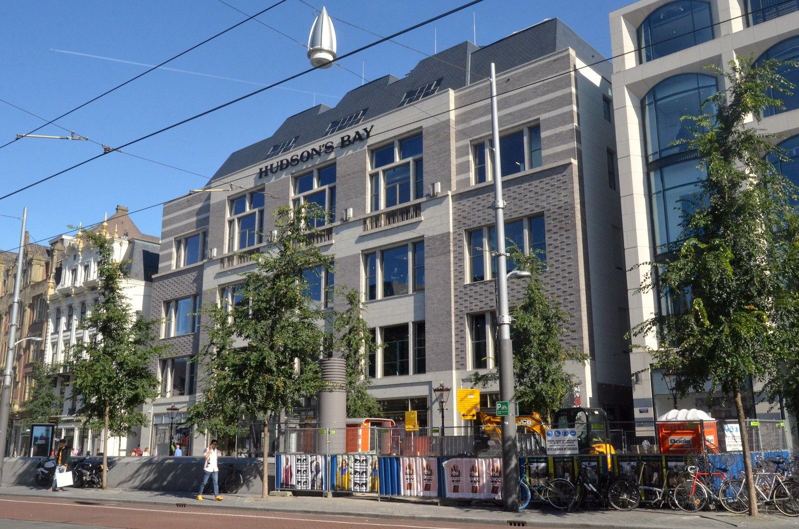 Adyen: Grey stone department store building on a street with trees and tram wires