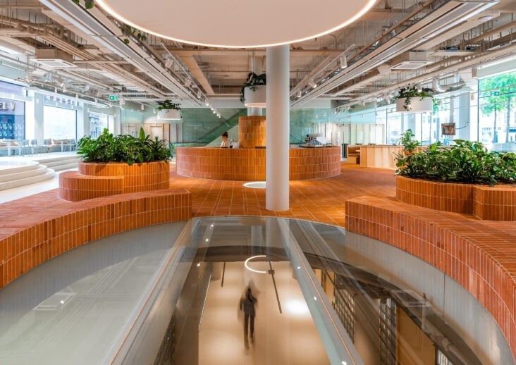 Adyen: Open floor with curved brick planters around a glass floor opening