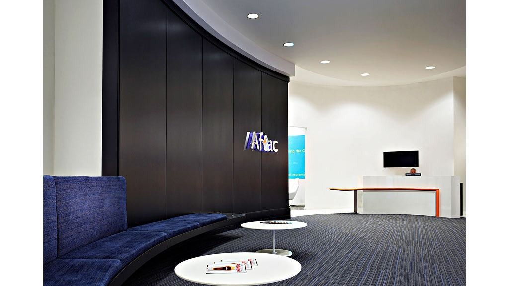 Aflac: A dark reception wall with the Aflac logo and a curved blue banquette