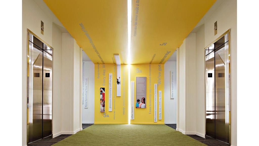 Aflac: An elevator lobby with a bright yellow ceiling and green carpet