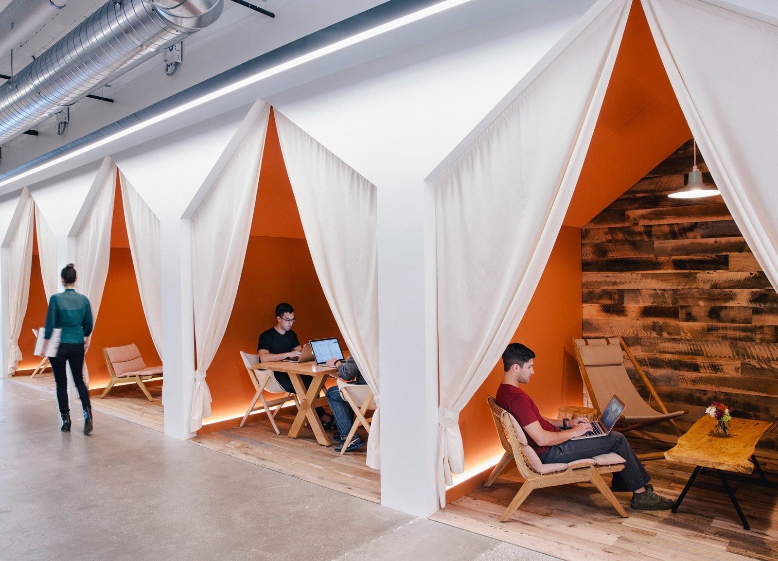 Airbnb: Work nooks under white fabric tents with orange walls