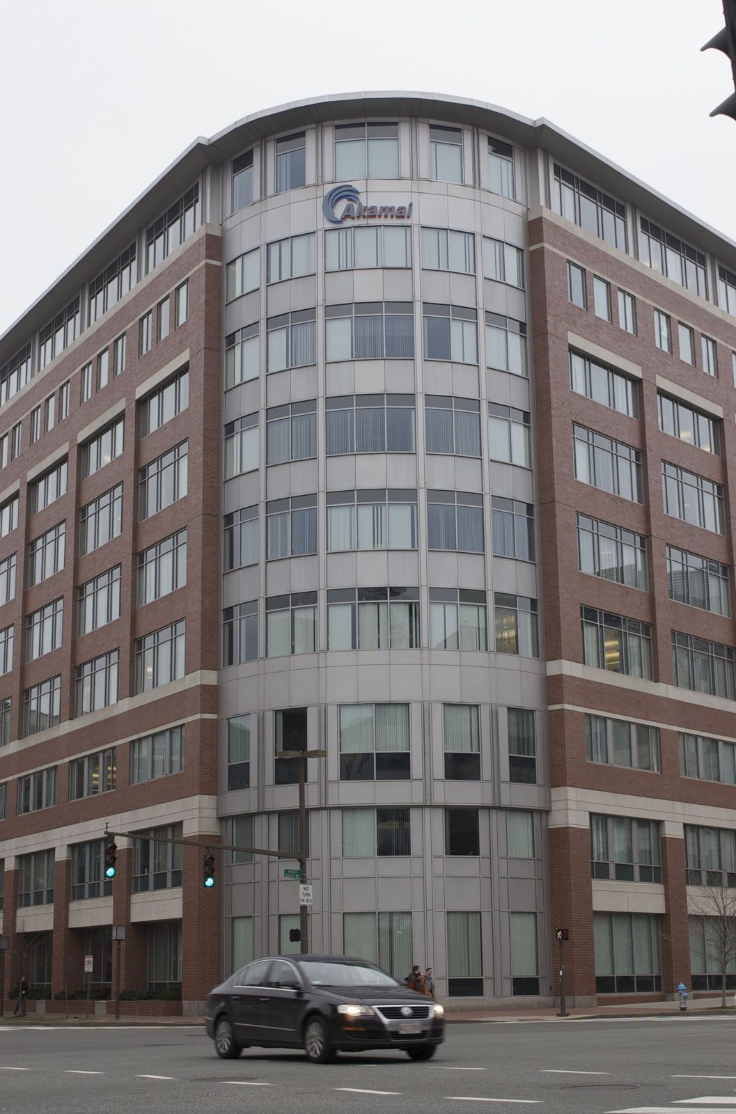 A curved brick and glass office building with the Akamai logo