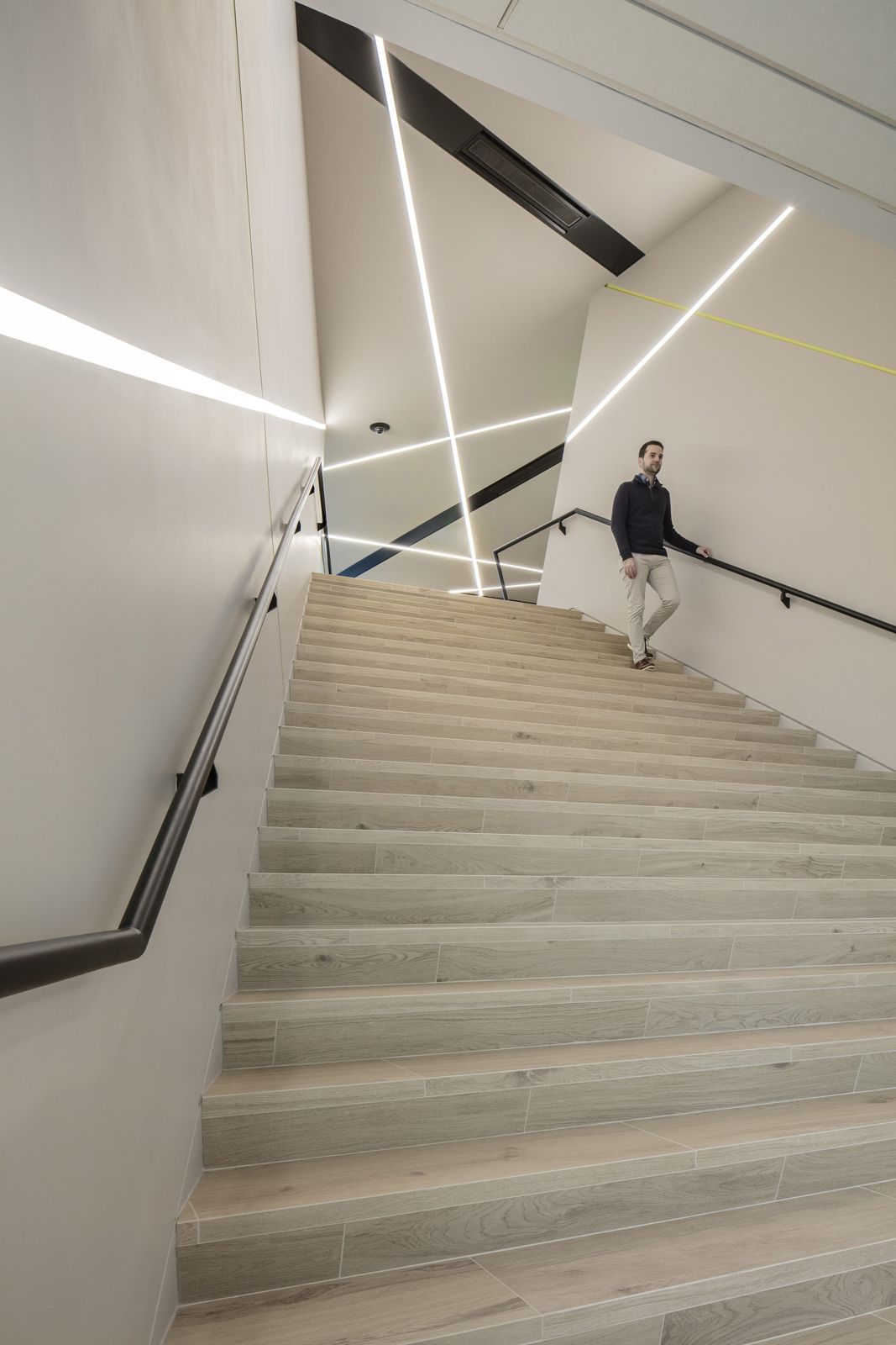 Akamai: A long straight stair with light lines on the walls