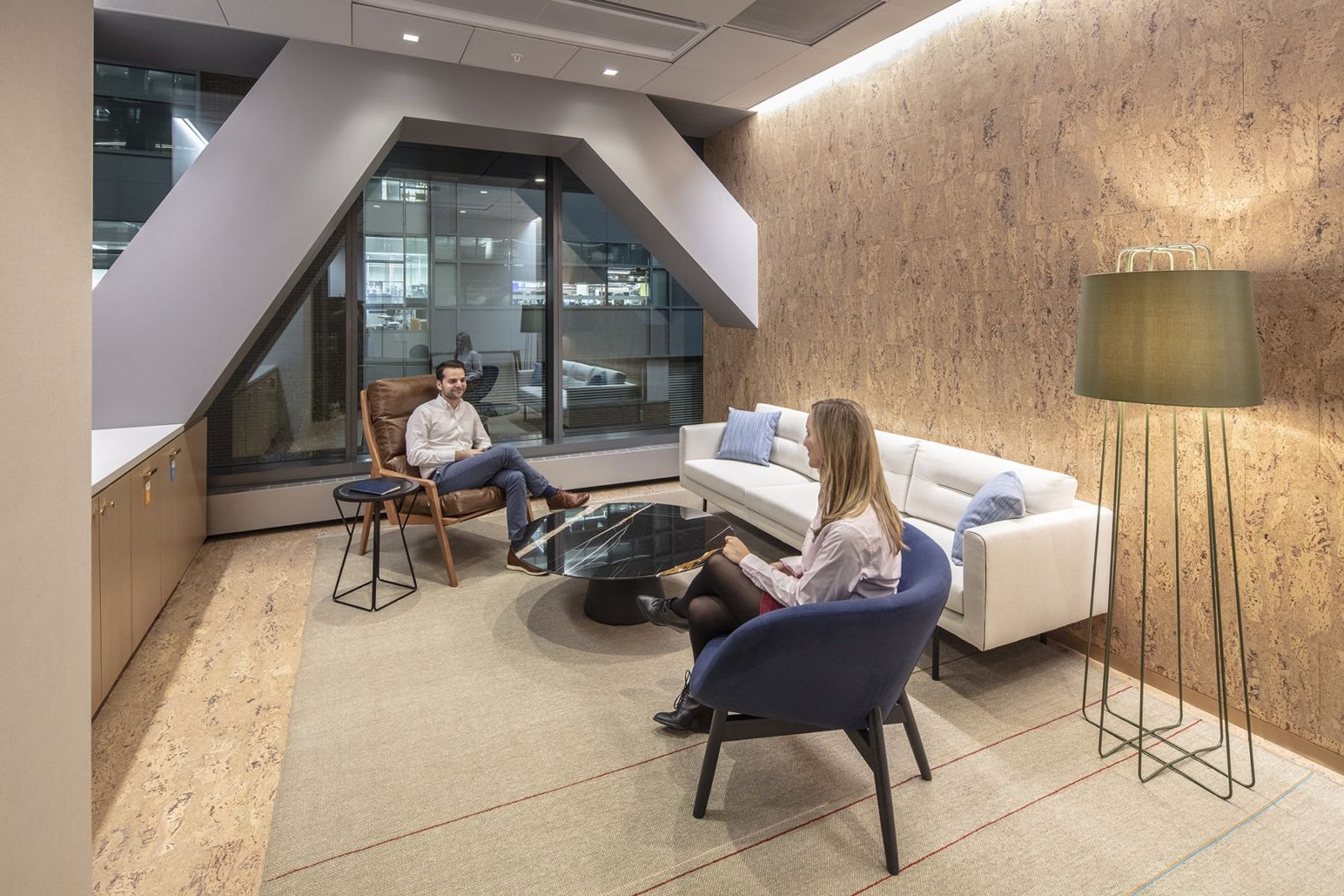 Akamai: A lounge with armchairs under an angled wood wall