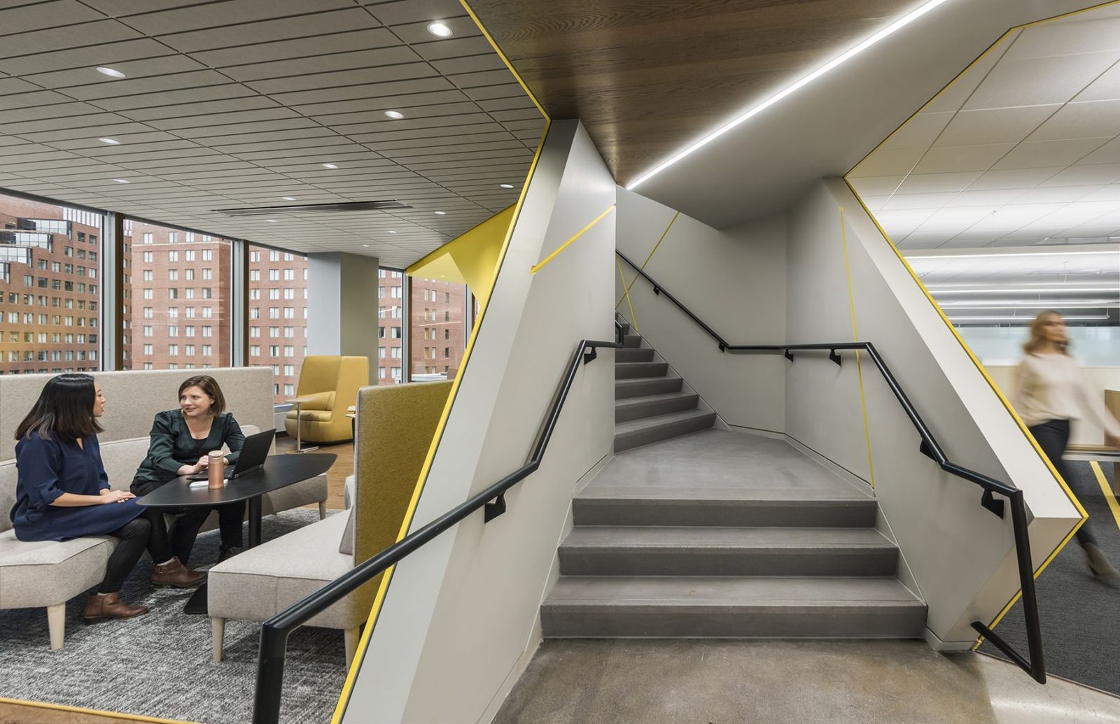 Akamai: A stair cutting through a lounge with sofas