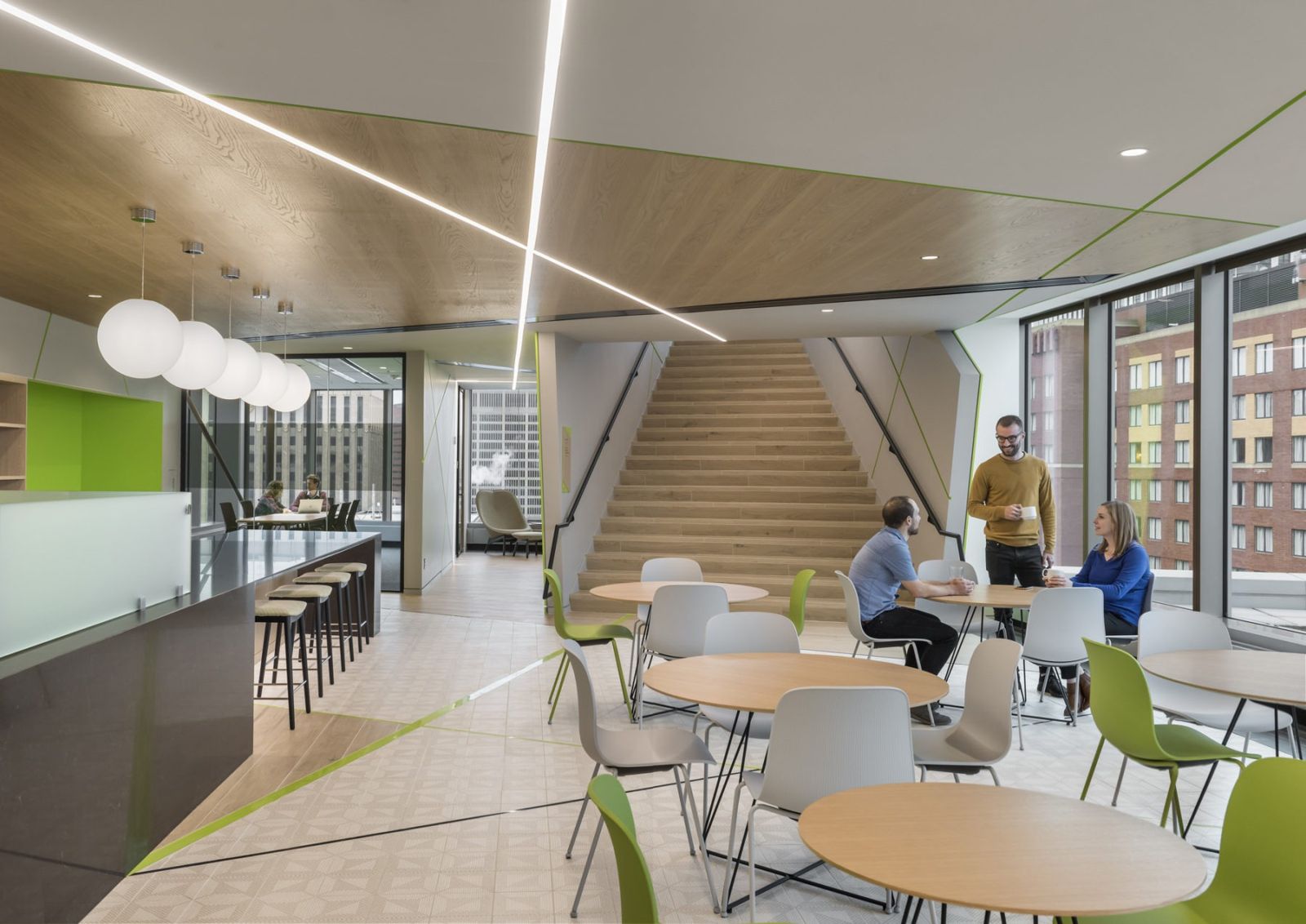Akamai: Café tables with green pendant lights near a wide stair