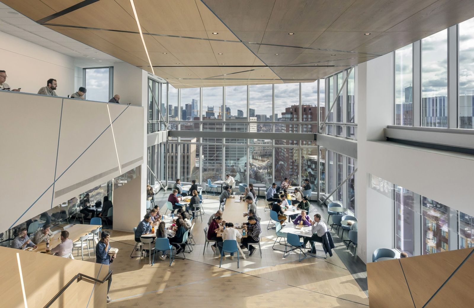 Akamai: Cafeteria tables in a tall room with city views