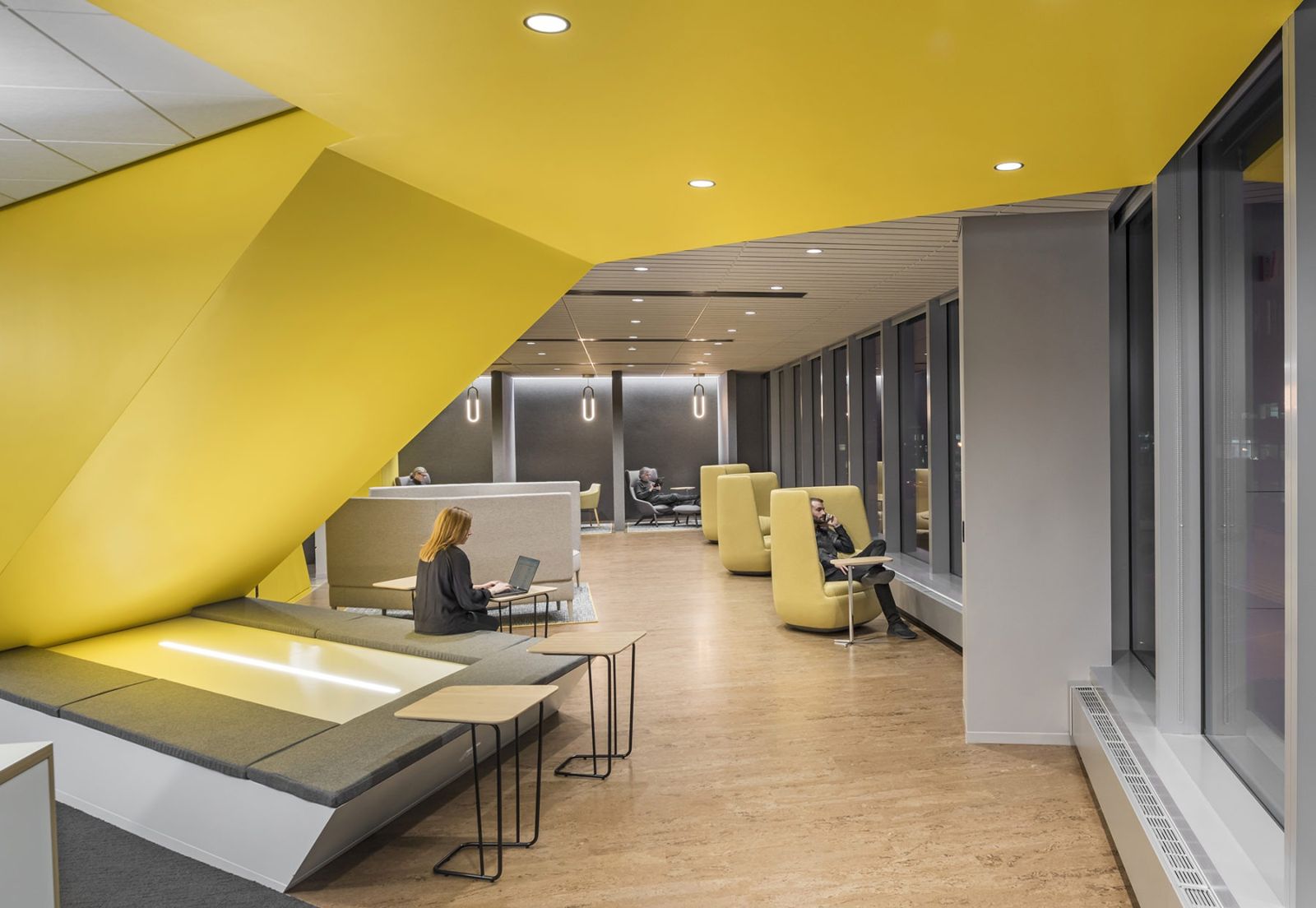 Akamai: Yellow angled ceiling over a lounge with built-in seating