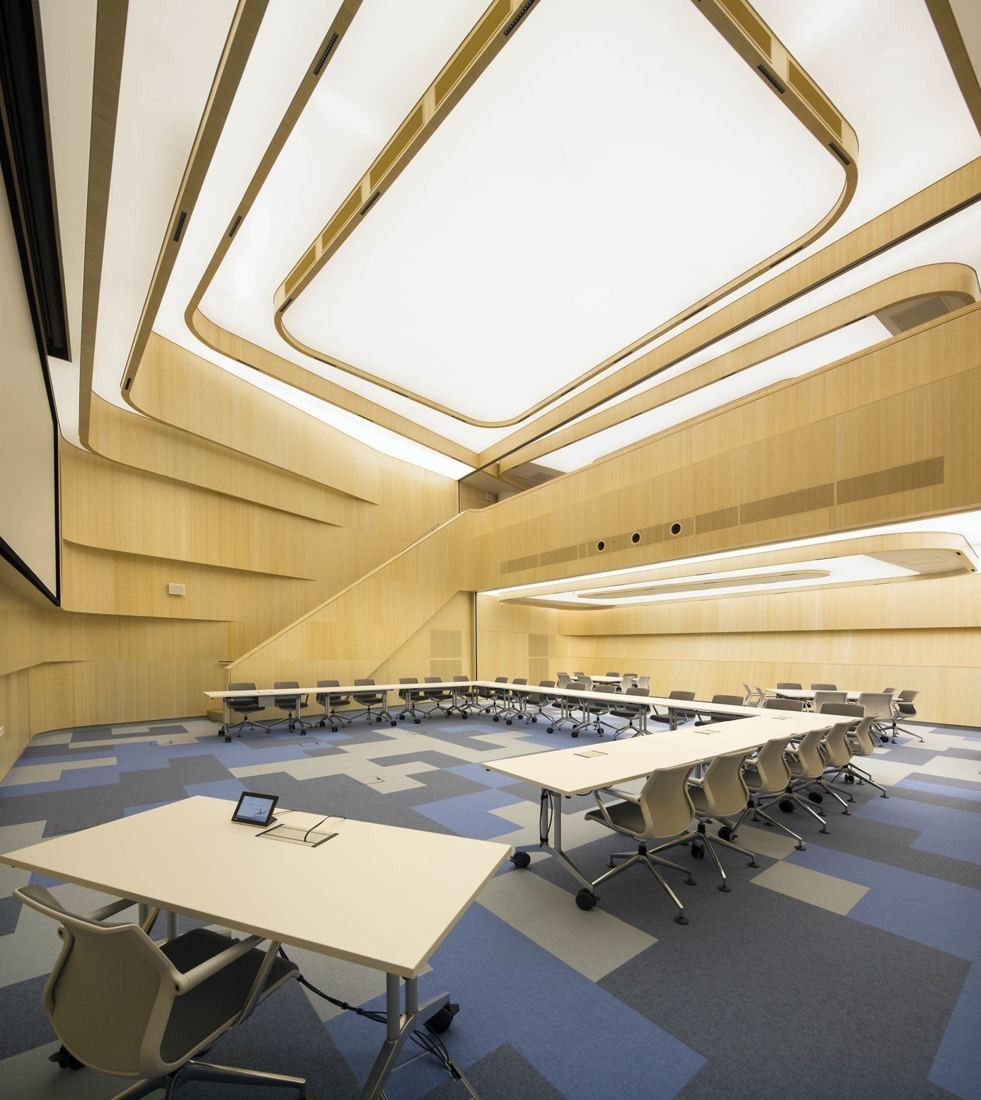 AkzoNobel: Auditorium with wood-clad walls, a sculpted light ceiling and tables in a U shape