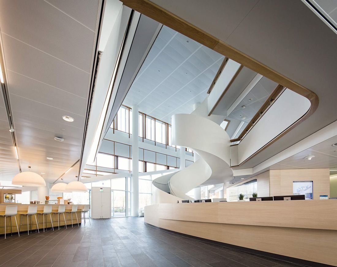 AkzoNobel: Bright entrance hall with a white spiral staircase and a long curved reception desk