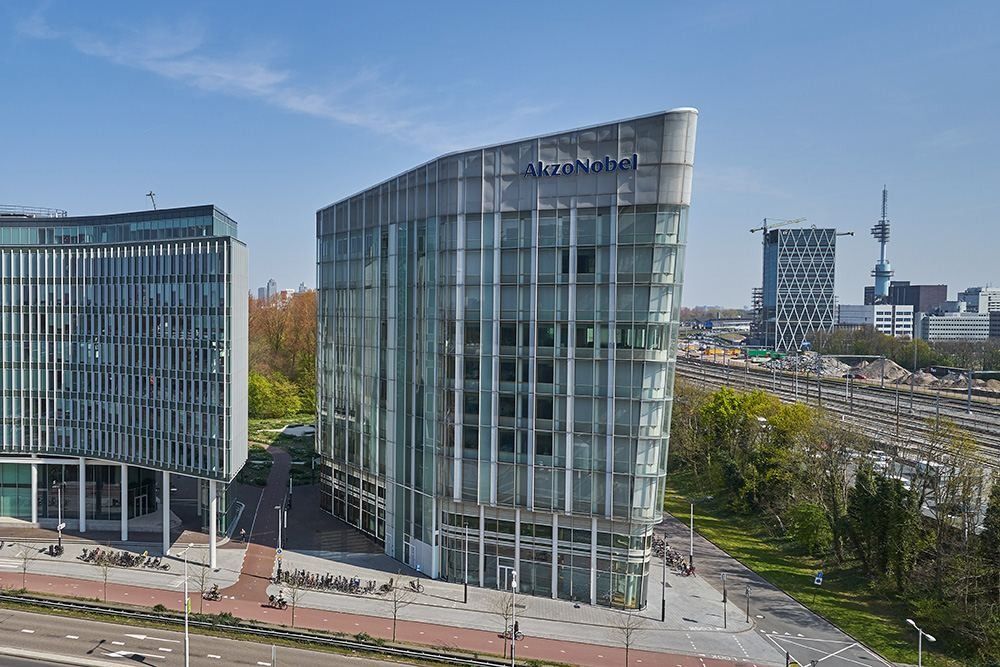 AkzoNobel: Elevated view of the glass office building beside a road and railway in Zuidas