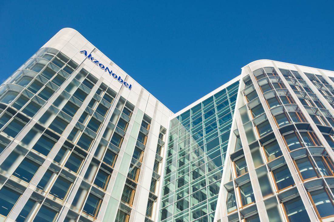 AkzoNobel: Looking up at curved glass façades with the AkzoNobel name against a blue sky