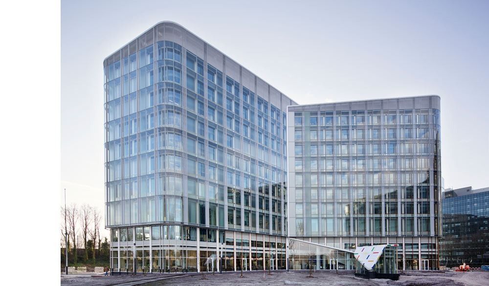 AkzoNobel: Two glass office volumes joined by a recessed entrance on a cloudy day