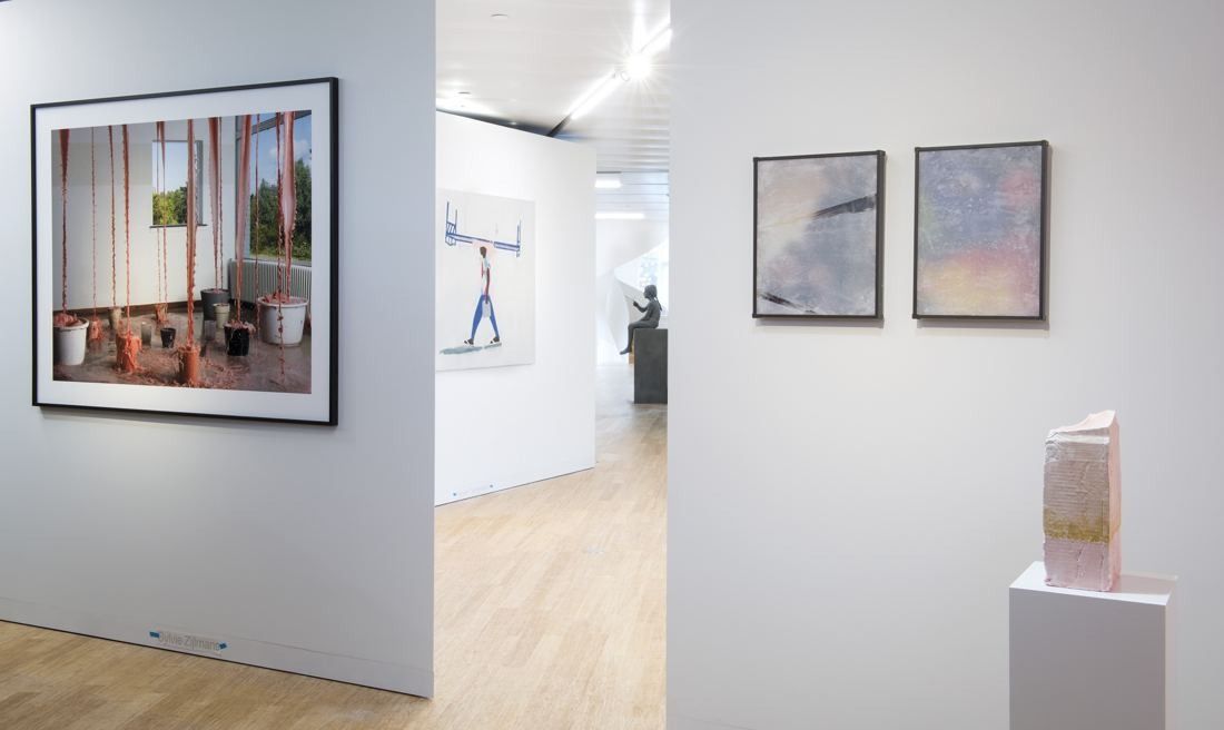 AkzoNobel: White gallery walls with framed photographs and a small sculpture on a plinth