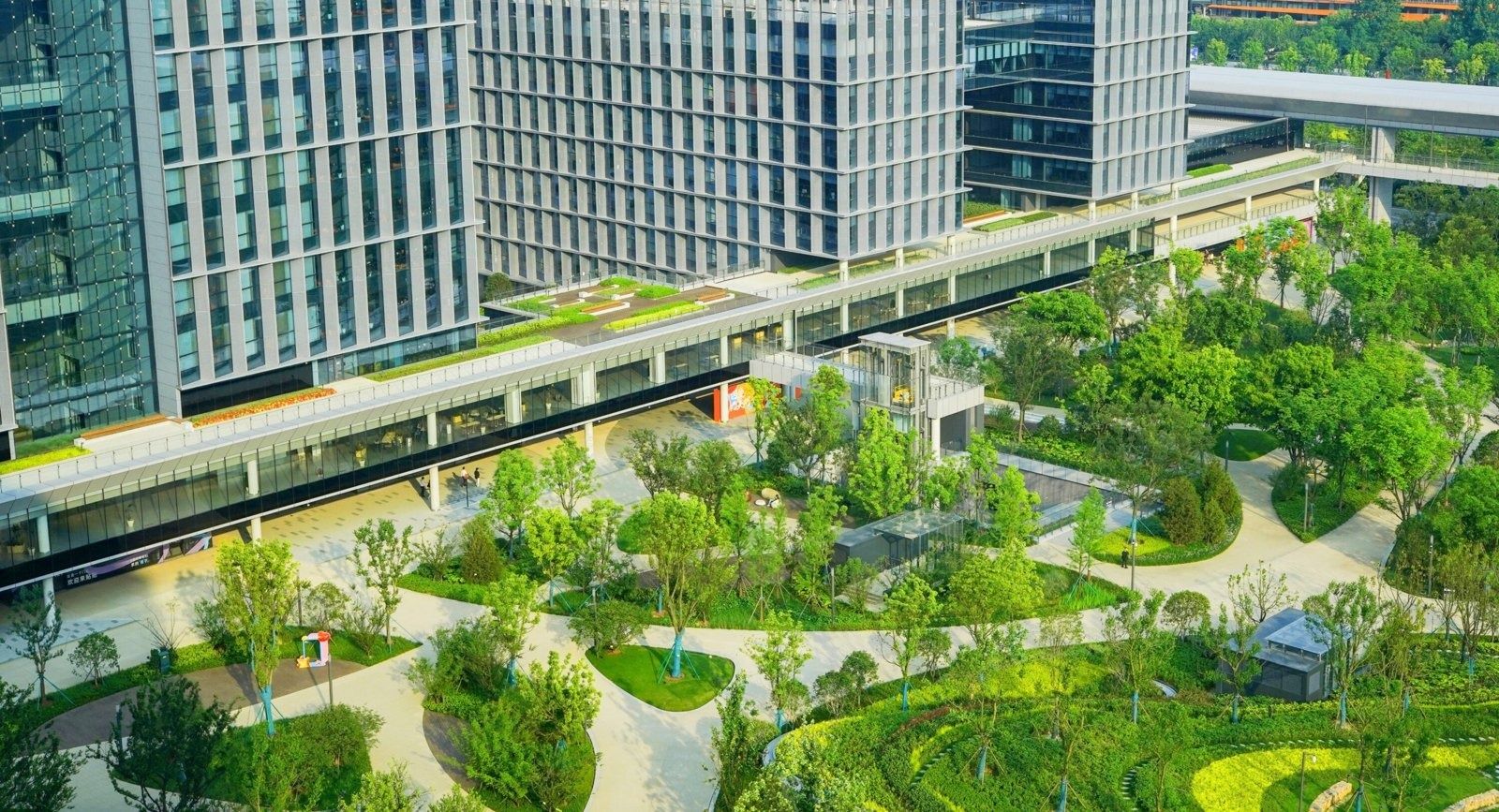 Alibaba Group: Elevated walkway curving through a green garden between buildings