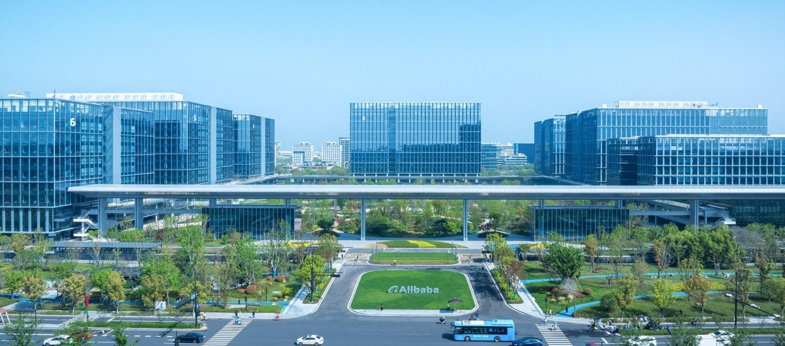 Alibaba Group: Low glass buildings beyond a lawn and road