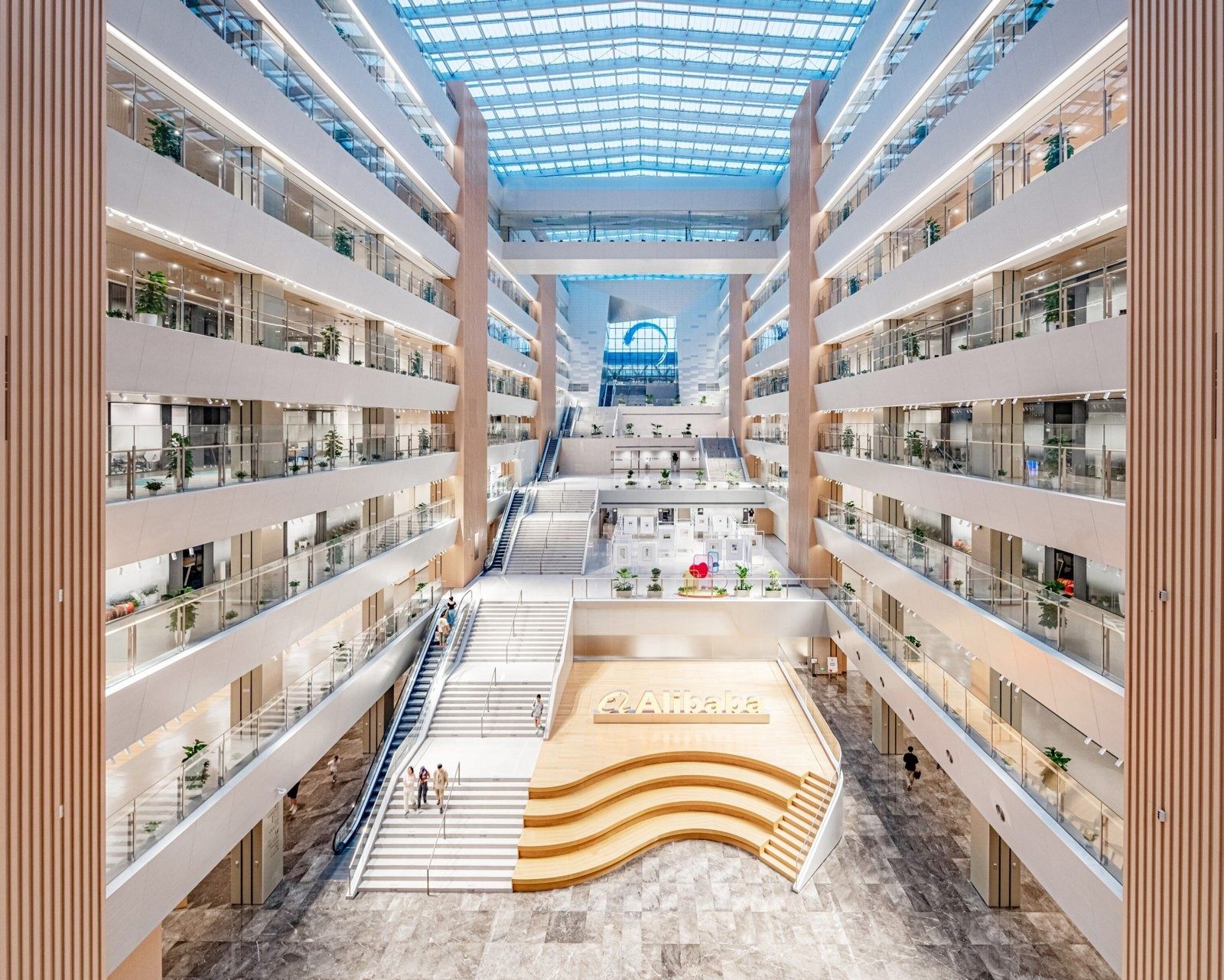 Alibaba Group: Tall atrium with wooden stepped seating and balconies on every floor