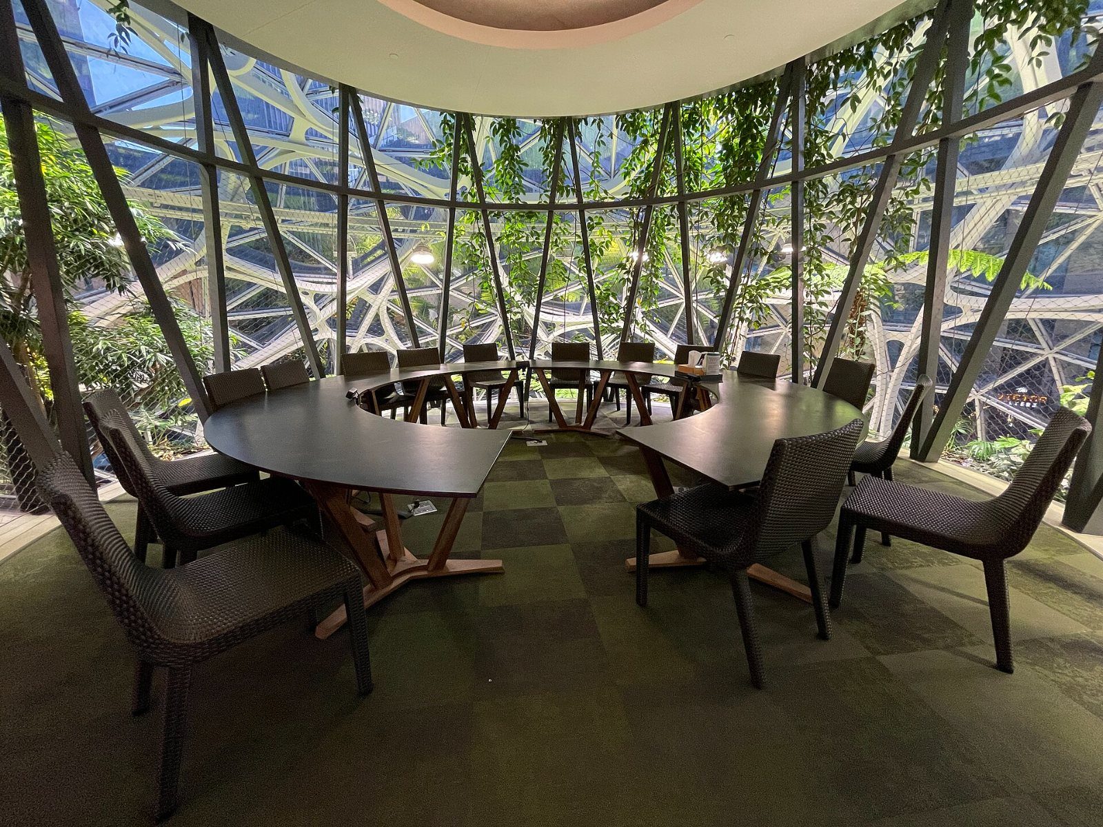 Tables and chairs among plants under a glass dome