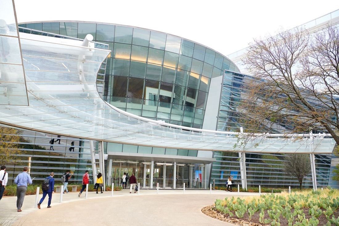 American Airlines: Glass building entrance under a curved white canopy with people walking in