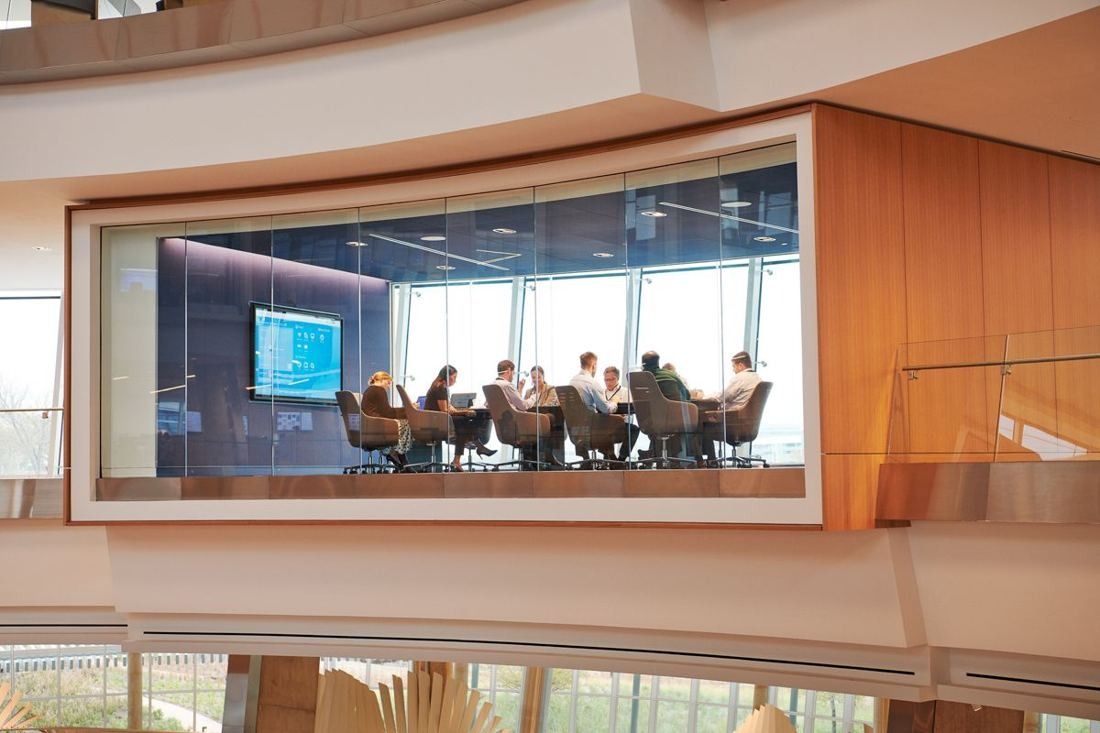 American Airlines: Glass-walled meeting room with wood paneling seen from across an open atrium