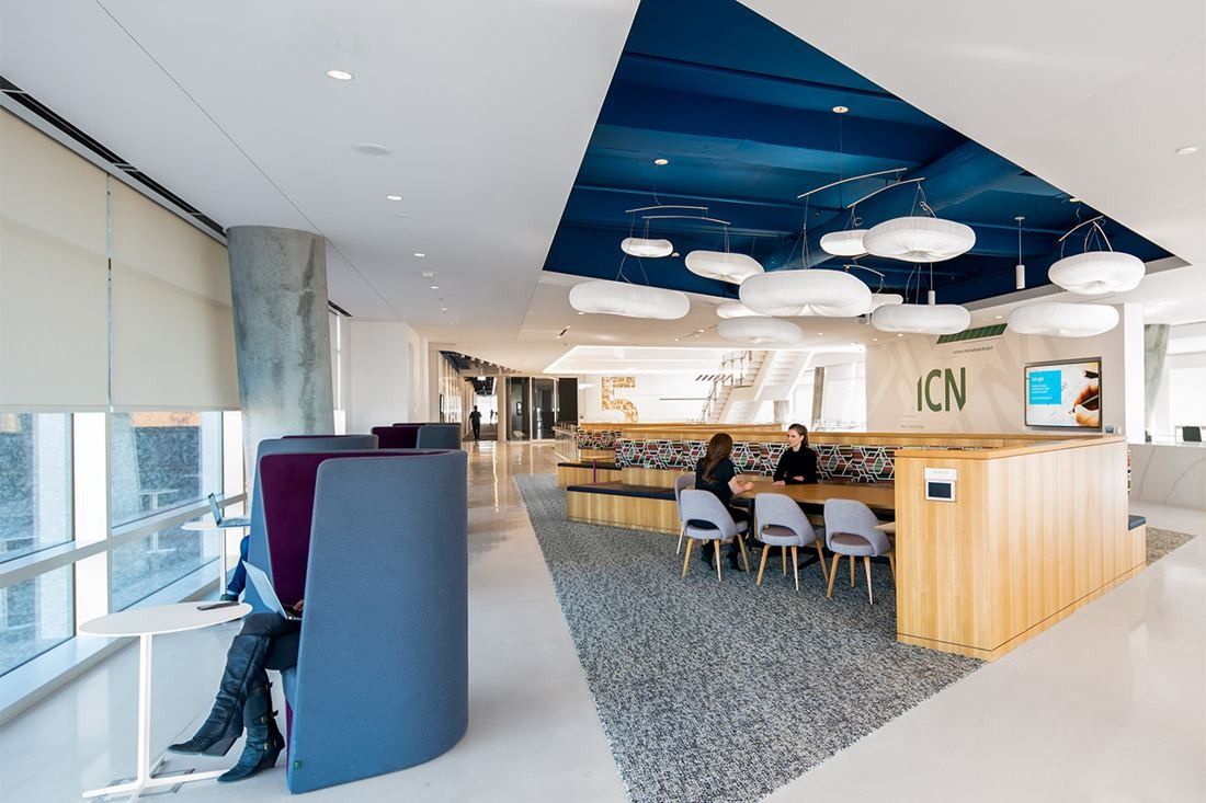 American Airlines: Open work area with high-backed booths, a long table and cloud-shaped pendant lights under a blue ceiling