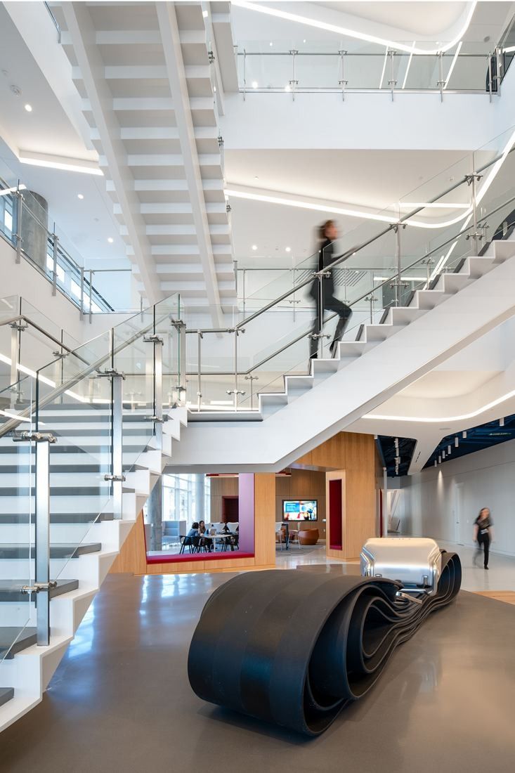 American Airlines: White open staircase with a dark curved bench sculpture below