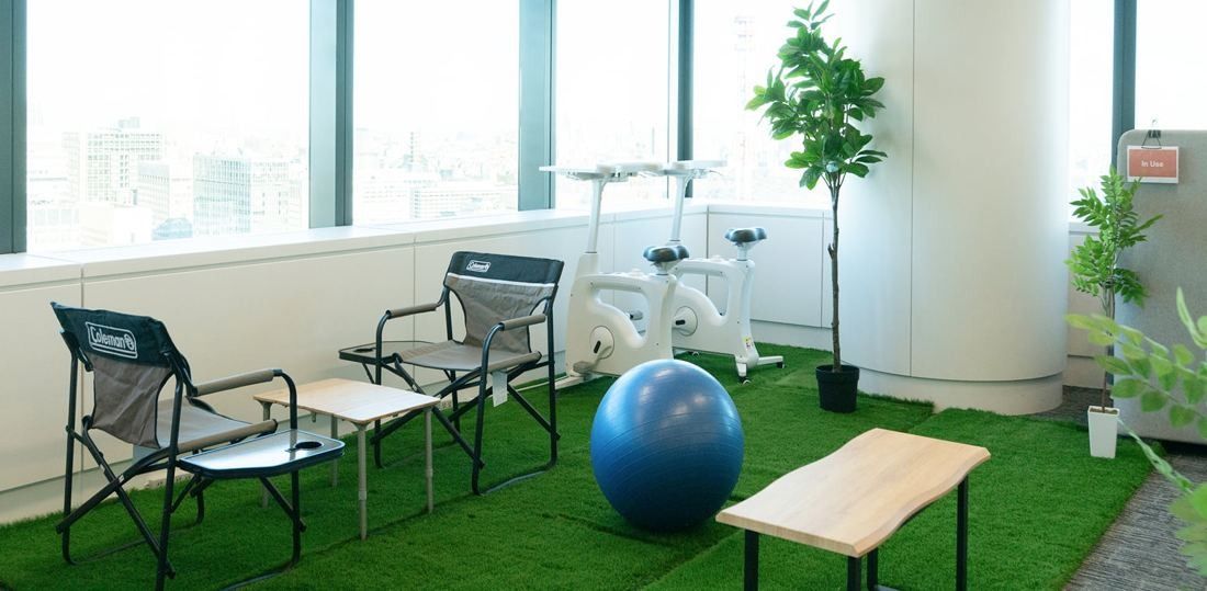 ANA: Corner with folding chairs, an exercise ball, an exercise bike and artificial grass by the windows