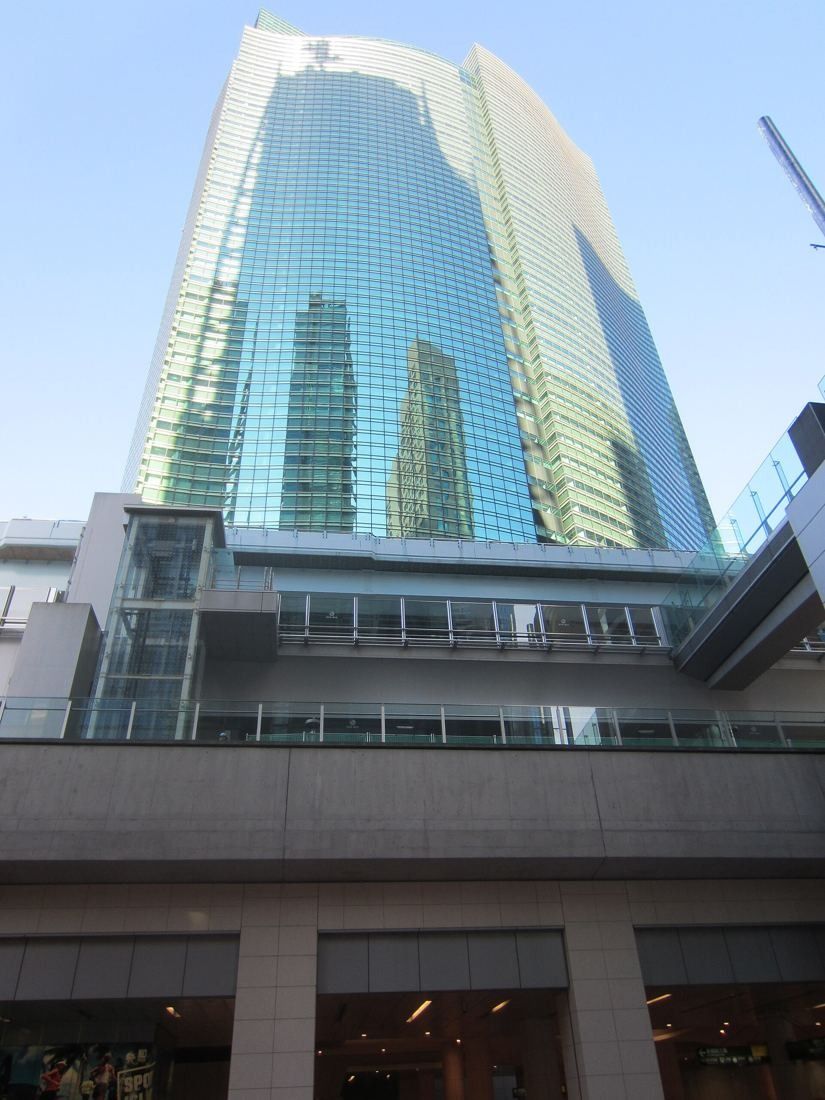ANA: Glass tower rising above a stone-clad podium with a terrace