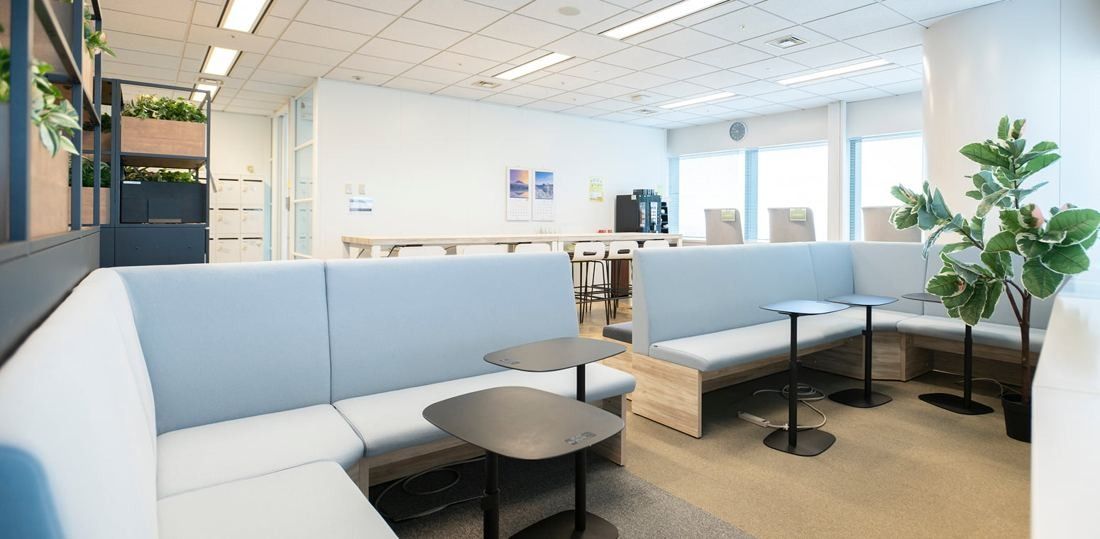 ANA: Lounge with light blue sofas, small round tables and potted plants