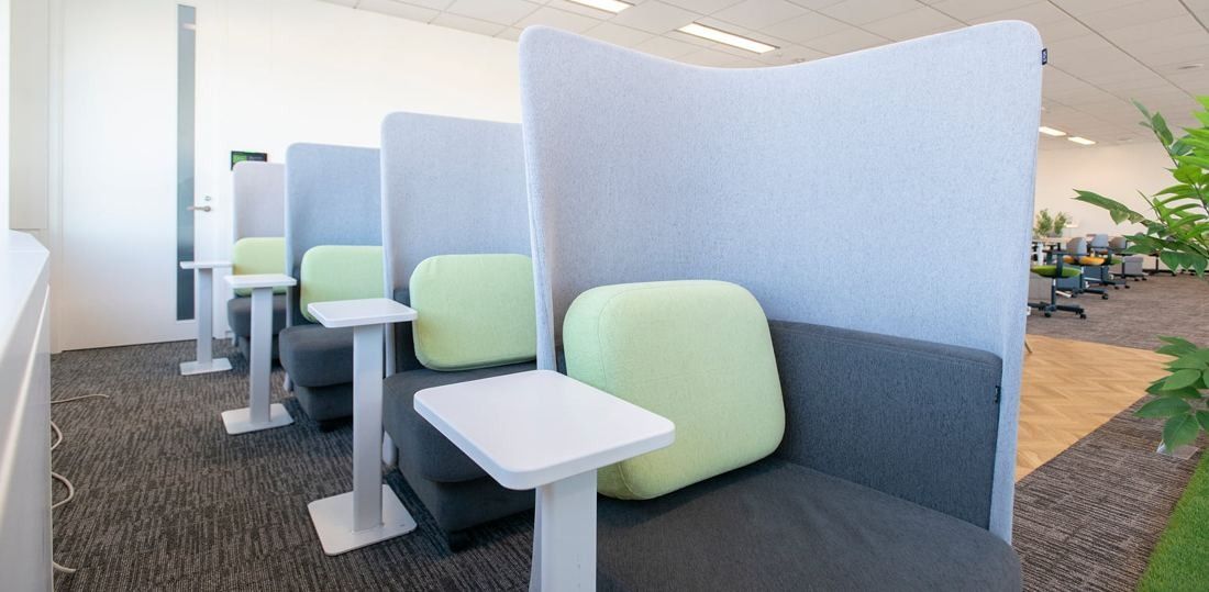 ANA: Row of high-backed booths with small tables and pale green cushions