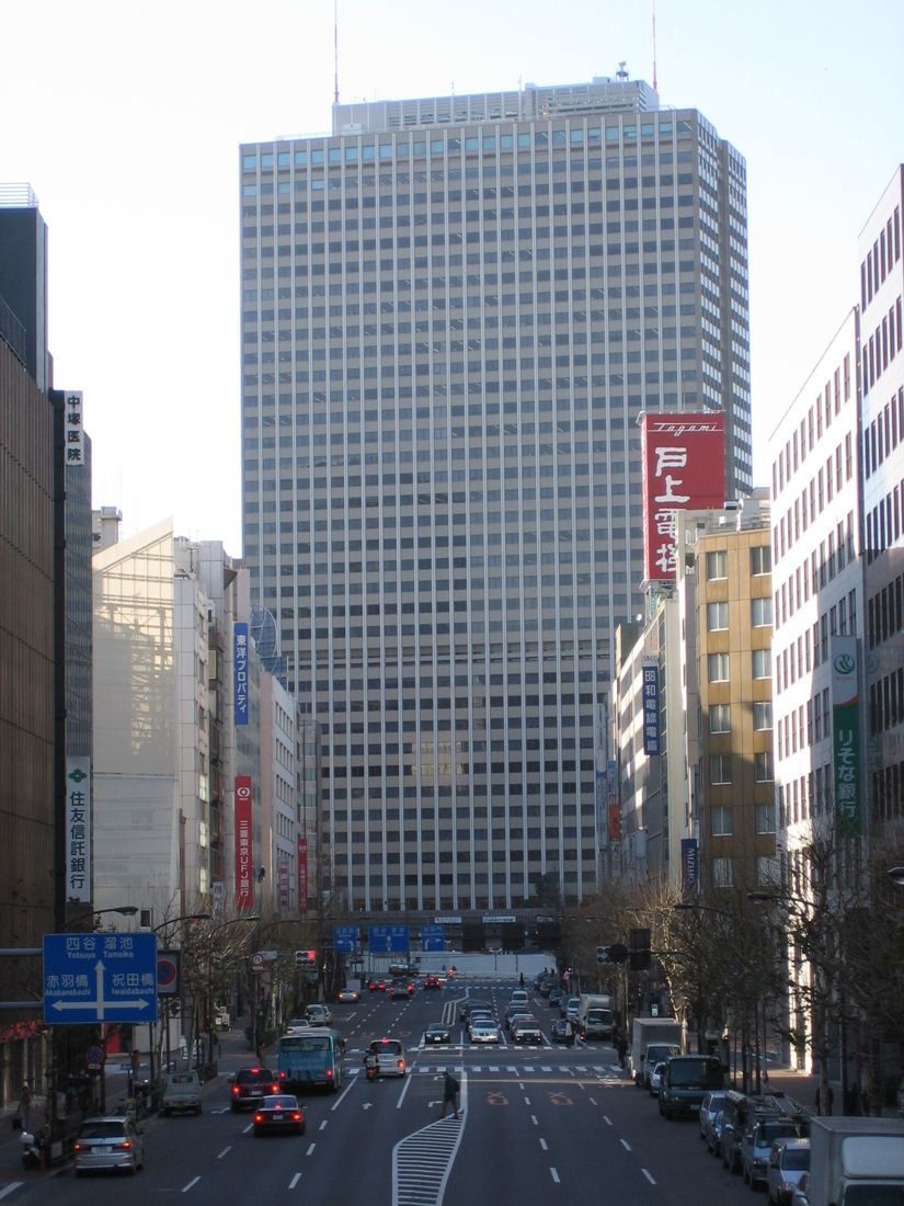 Tall grid-facade office tower at the end of a city street