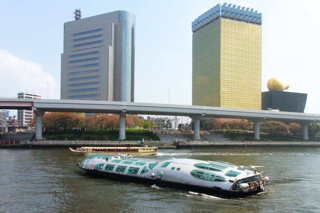 Asahi Group Holdings: A futuristic river bus on the Sumida River in front of the gold tower
