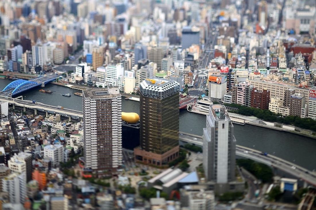 Asahi Group Holdings: Aerial view of the river bend with the gold tower and golden flame among the city