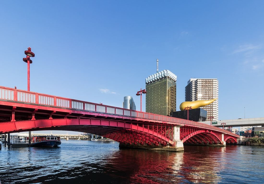 Asahi Group Holdings: Red Azuma Bridge over the river with the gold tower and flame beyond