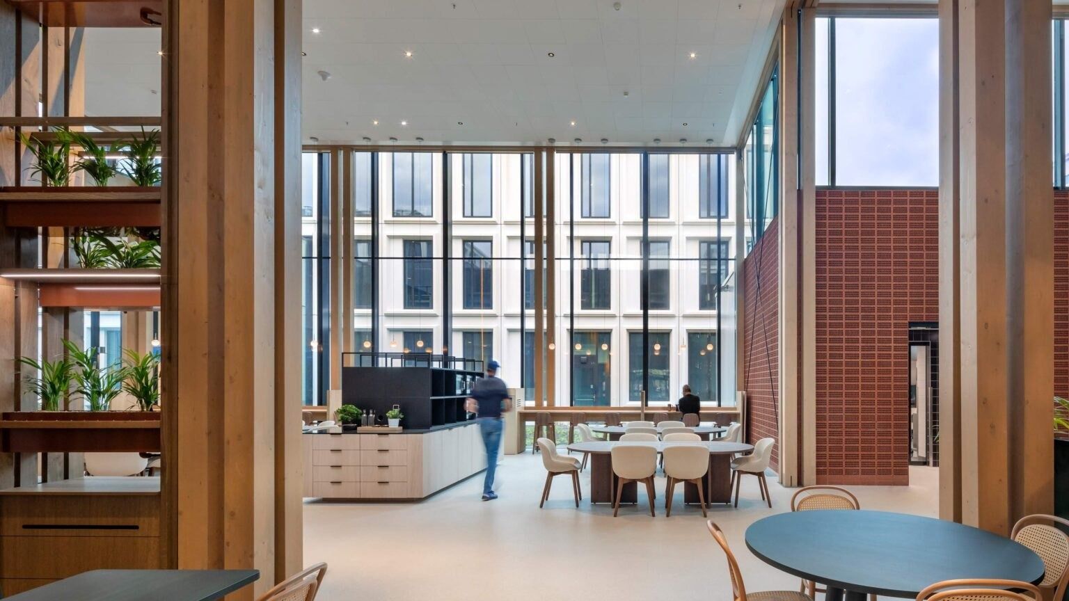 A café counter with plants and tall windows