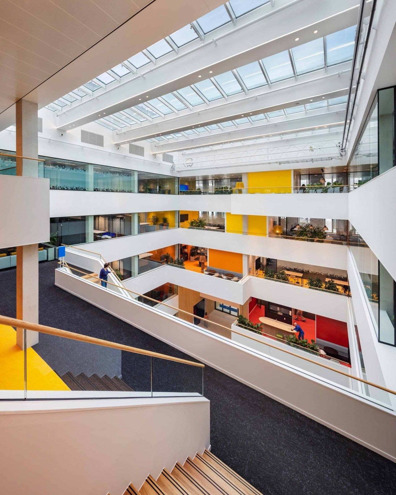 A white atrium with balconies under a skylight