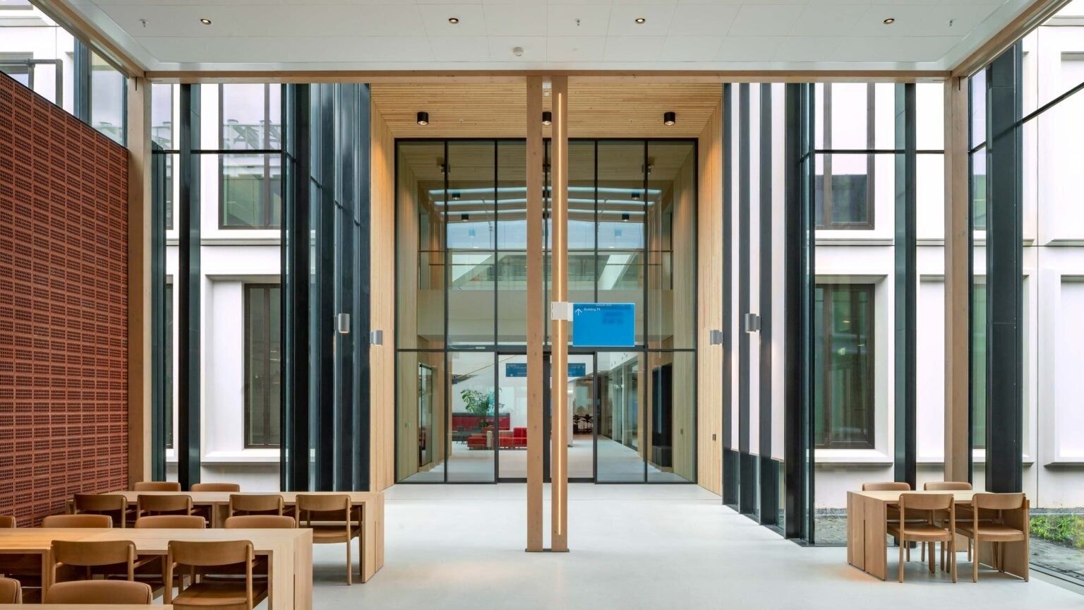 Long wooden tables in a tall glazed space