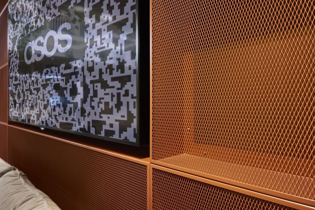 ASOS: Copper mesh wall panel next to a screen and a sofa