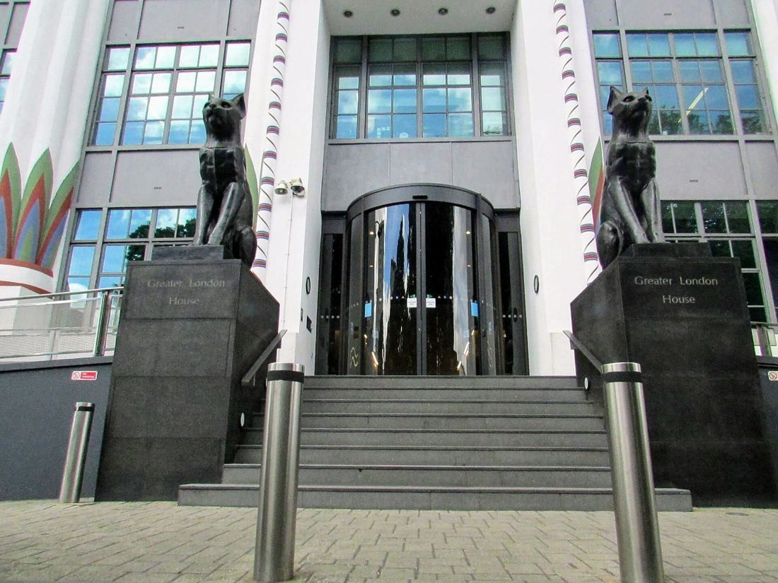 ASOS: Entrance steps flanked by two black cat statues and a revolving door