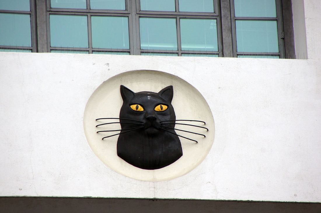 ASOS: Round wall plaque with a black cat face below a window