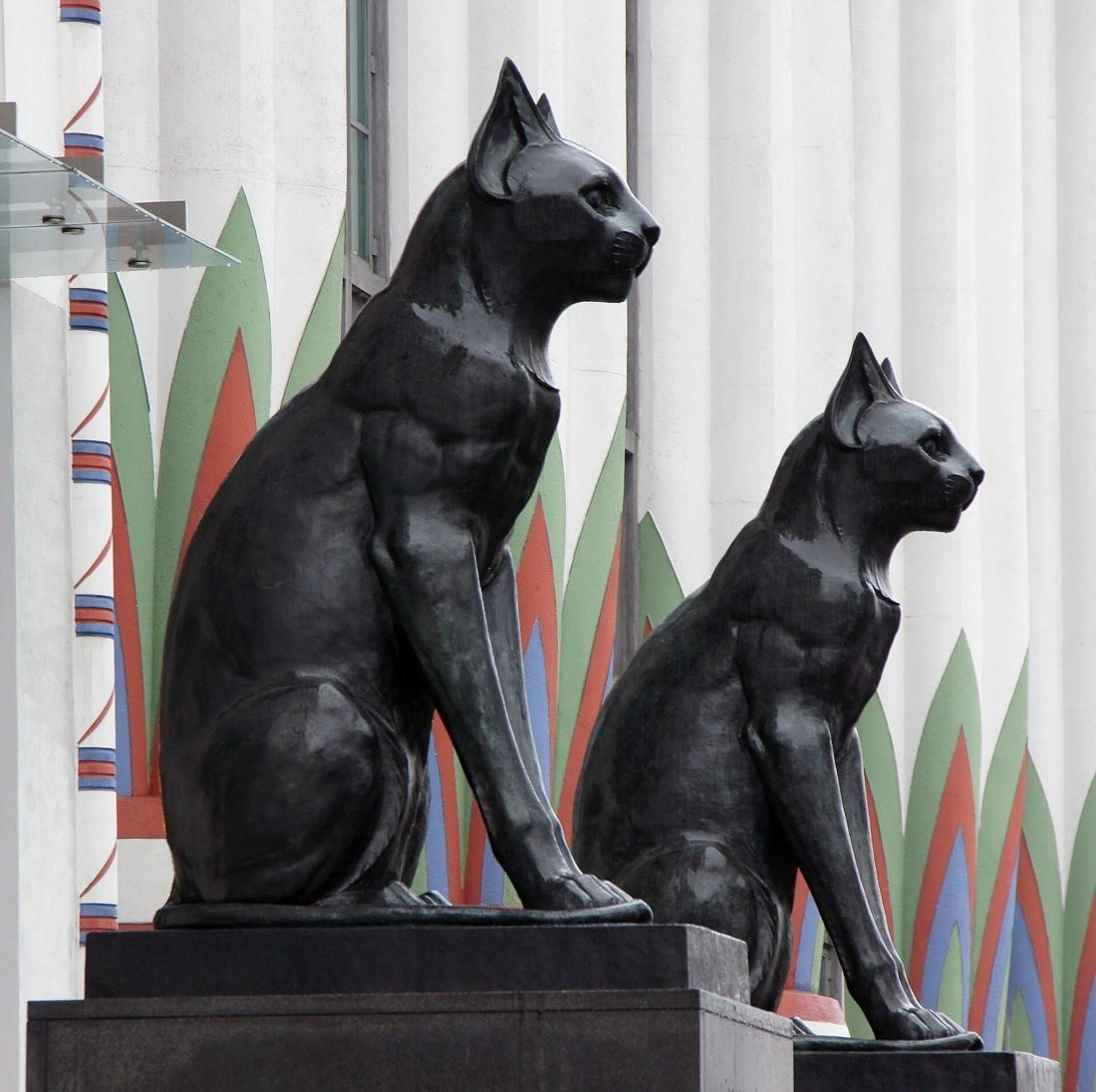 ASOS: Two black cat statues in front of a painted Egyptian-style column