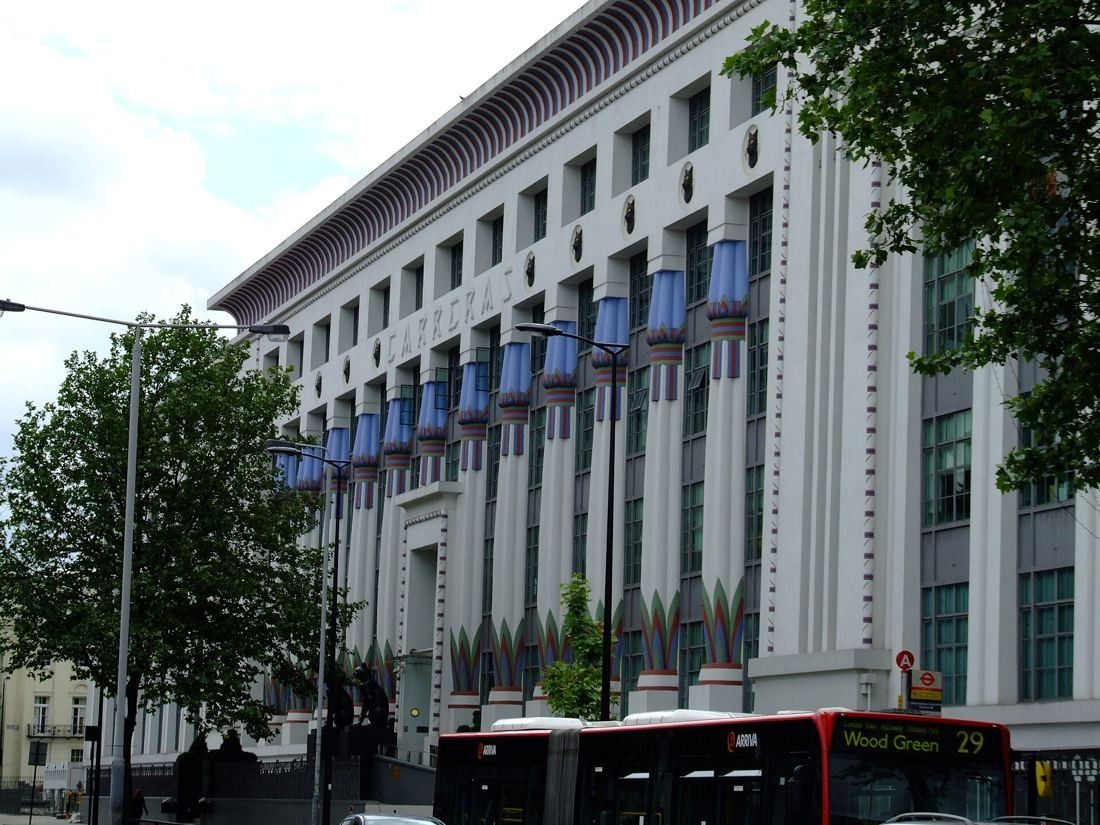 ASOS: White facade with blue-topped columns behind a tree and a red bus